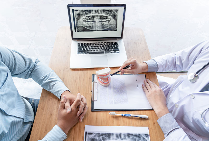 A woman sitting at a desk in an office, working on a computer.
