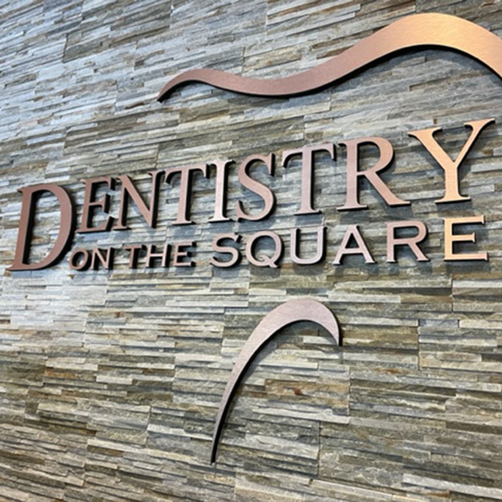 The image shows a dental office interior with a dental chair, a dental light, and various dental equipment.